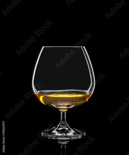 Cognac glass with drink on black