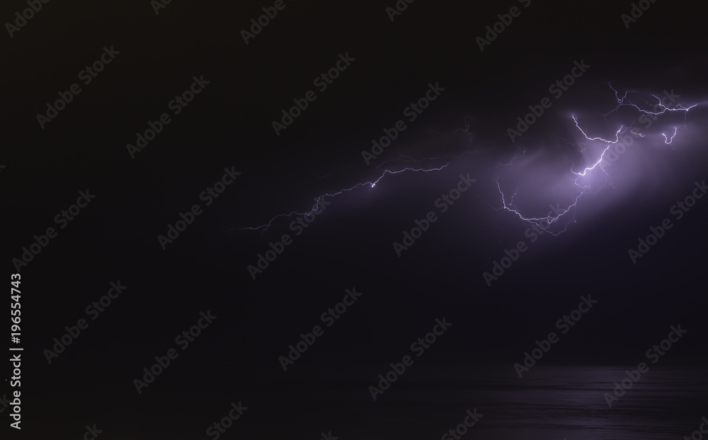 lightning bolts reflection over the sea. taken during a thunderstorm over the ocean with clouds in the background lightning bolts reflection over the sea. taken during a thunderstorm over the ocean with clouds in the background