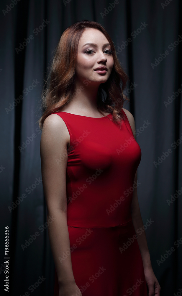 Girl in a red dress on a dark background Girl in a red dress on a dark background