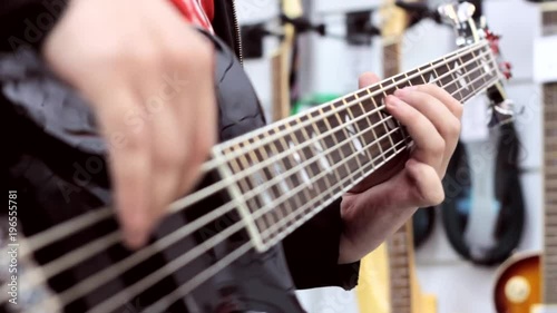the guitarist plays the bass guitar in the music store