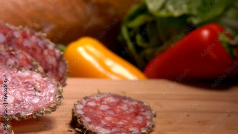 Slices of smoked spase sausage falls on a wooden board Slices of smoked spase sausage falls on a wooden board
