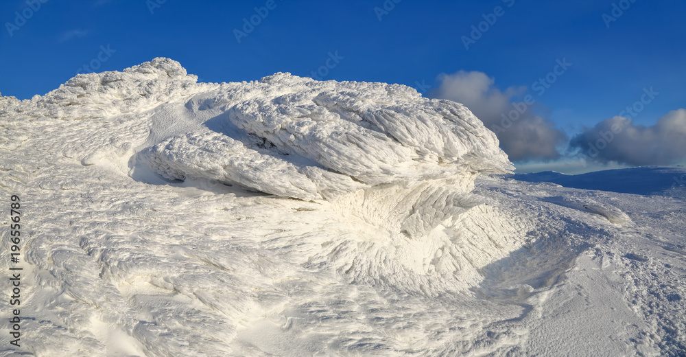 High mountains and blue sky. Mysterious fantastic rocks frozen with ice and snow of strange fairytales forms and structures. Cryptic landscape. Carpathian national park, Chornohirskiy ridge.
