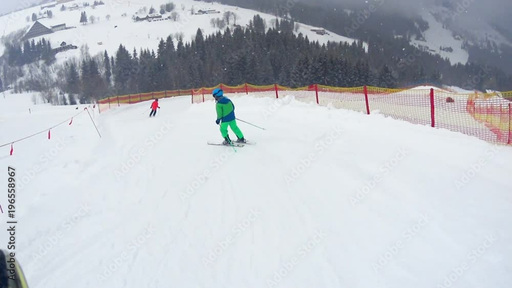 Skiers, mostly children, skiing downhill in snowy winter mountains. Ski goggles visible on the left
Skiers, mostly children, skiing downhill in snowy winter mountains. Ski goggles visible on the left