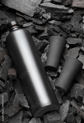 Original black matte bottle of vodka or tequila and black shot glass .On charcoal background. Black edition.Creative.Let's drink.Cheers.Mockup photo