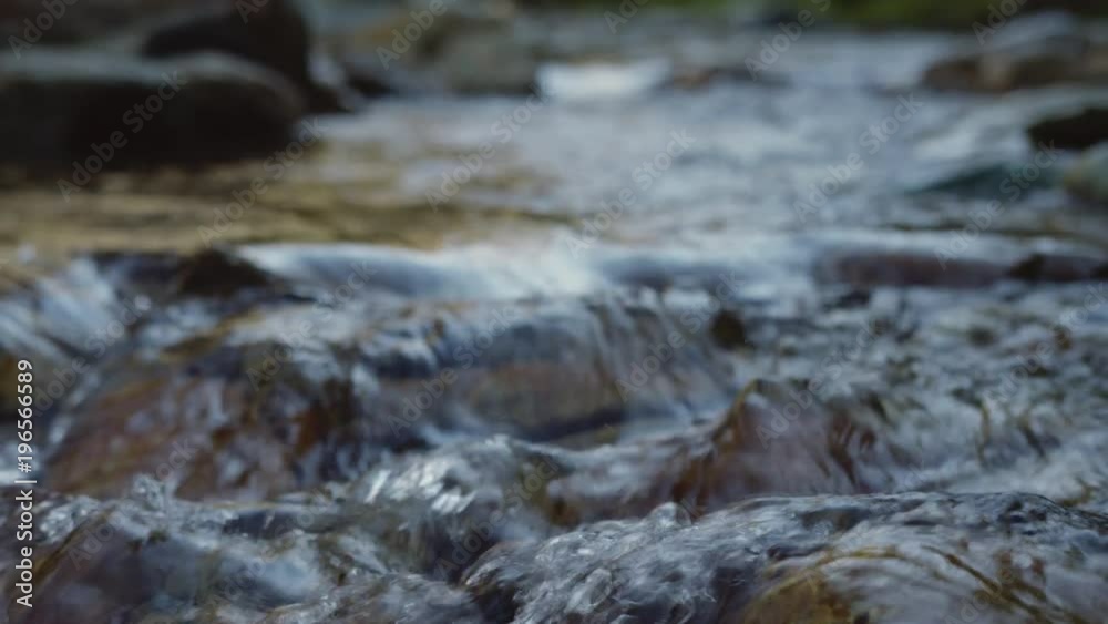 Close up slow motion shot of water smoothly flowing down a stream. Close up slow motion shot of water smoothly flowing down a stream.