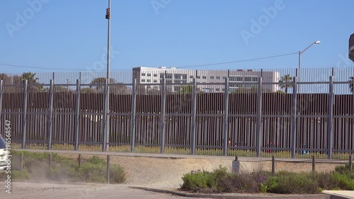 A Border Patrol vehicle passes in front of the border wall between San Diego and Tijuana. photo