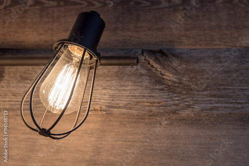 Bathroom lighting with rustic metal light bulb cage on a background of weathered wood