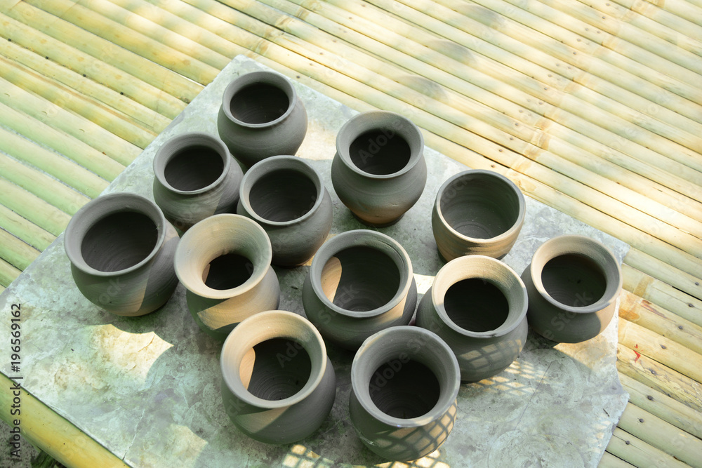 the earthen pots after finished of sculpt drying at bamboo table the earthen pots after finished of sculpt drying at bamboo table