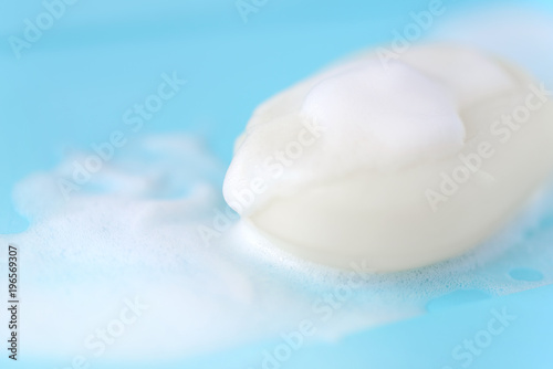 Soap foam bubbles on blue background macro close up.