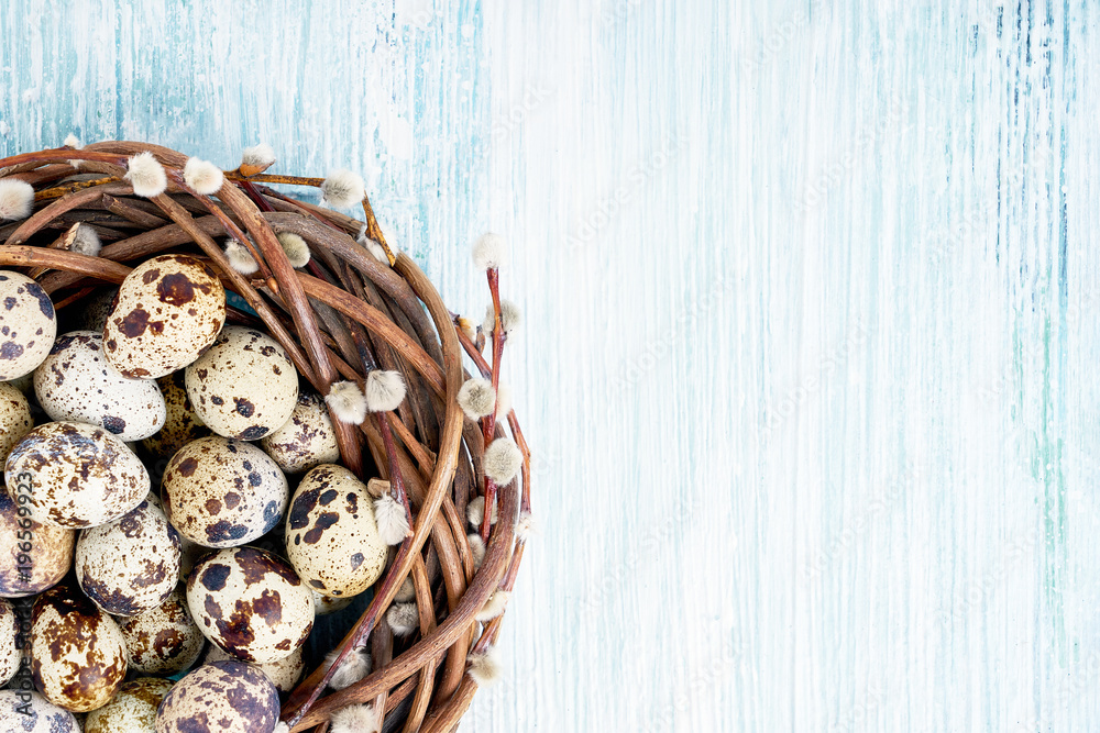 Easter willow wreath and quail Easter eggs on light blue background. Top view, copy space Easter willow wreath and quail Easter eggs on light blue background. Top view, copy space