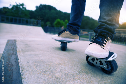 Freeline skateboarder legs riding on freeline at skatepark photo