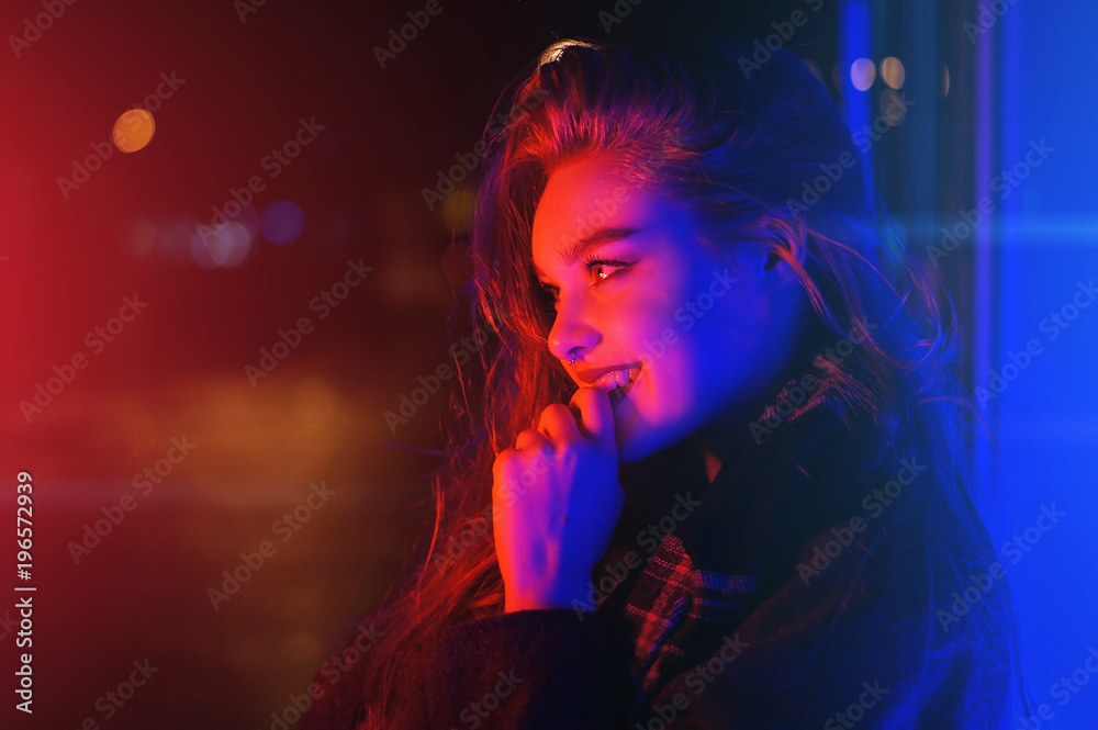 Sexy young woman posing over night city dramatic neon background