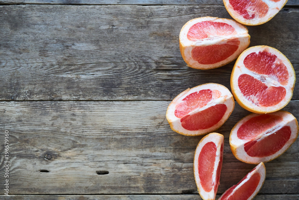 Slices of ripe and fresh grapefruit on a wooden table Slices of ripe and fresh grapefruit on a wooden table