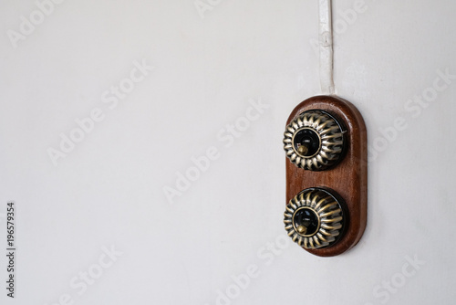 Vintage electrical switch on white wall, free copy space