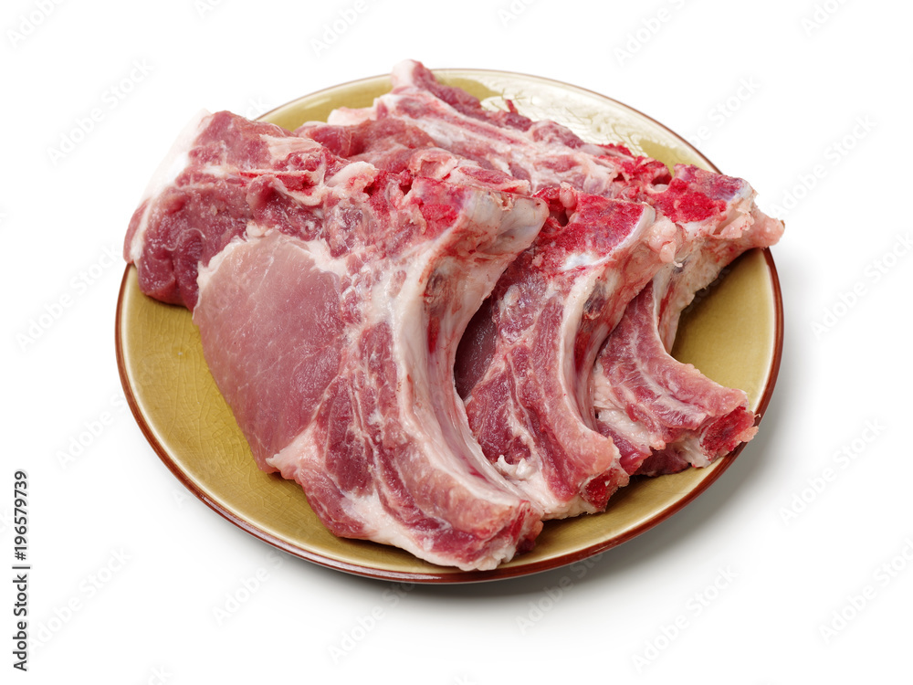 Raw pork ribs on plate isolated on whiteboard Raw pork ribs on plate isolated on whiteboard