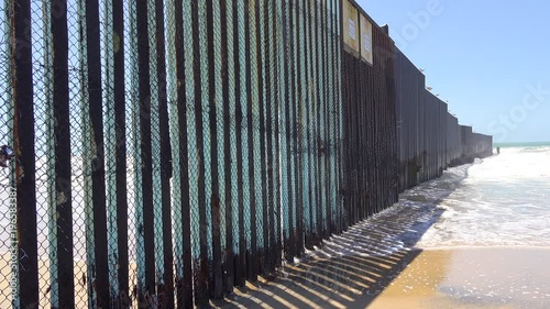 Waves roll into the beach at the U.S. Mexico border fence in the Pacific Ocean between San Diego and Tijuana. photo