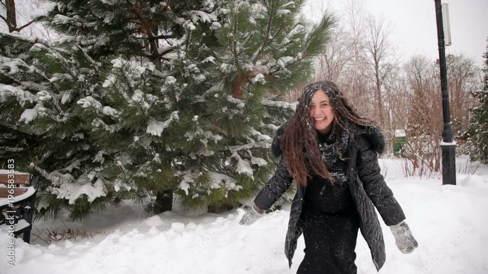Happy pregnant girl throws up snow and whirls around herself in a snowy forest. Portrait of a happy pregnant girl who has fun in the winter Park. Happy pregnant girl throws up snow and whirls around herself in a snowy forest. Portrait of a happy pregnant girl who has fun in the winter Park.