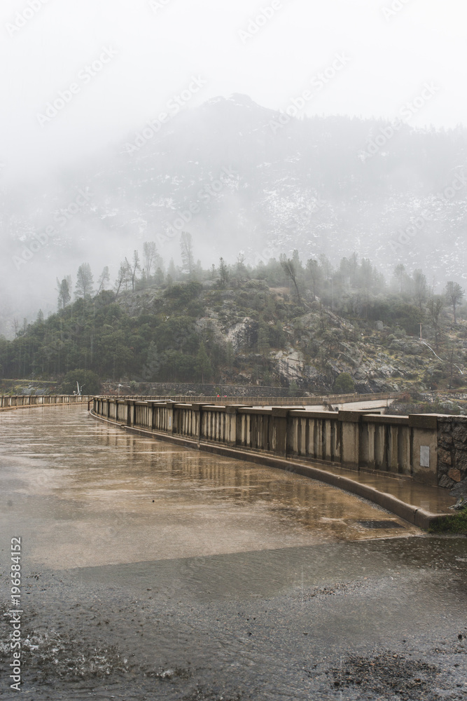 Fogs Among Trees, Dam, and Mountains on a Rainy Day in Hetch Hetchy Reservoir Area in Yosemite National Park, California