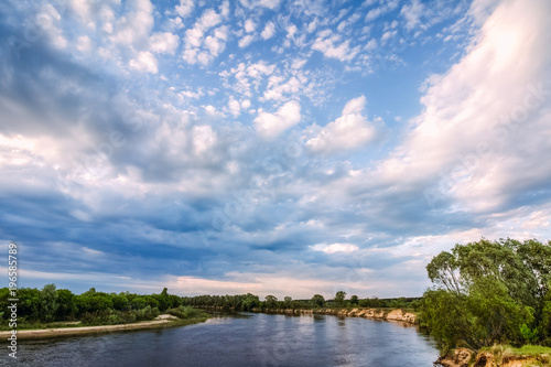 Landscape with a river and clouds in a blue sky © Zayne C.