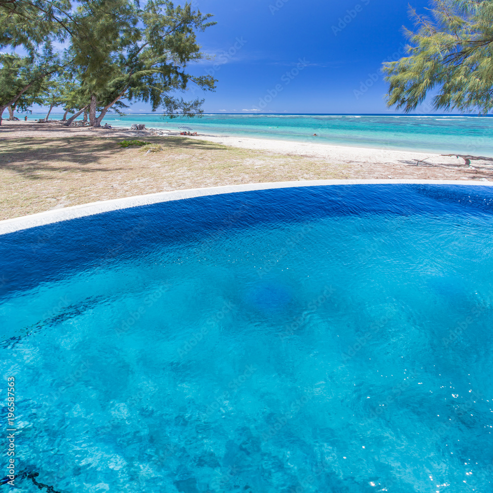 piscine à débordement sur fond de plage tropicale 