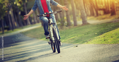 Fototapeta Naklejka Na Ścianę i Meble -  happy woman cyclist riding bike in spring tropical park