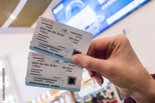 Two tickets in a woman's hand for travel by high-speed train CRH