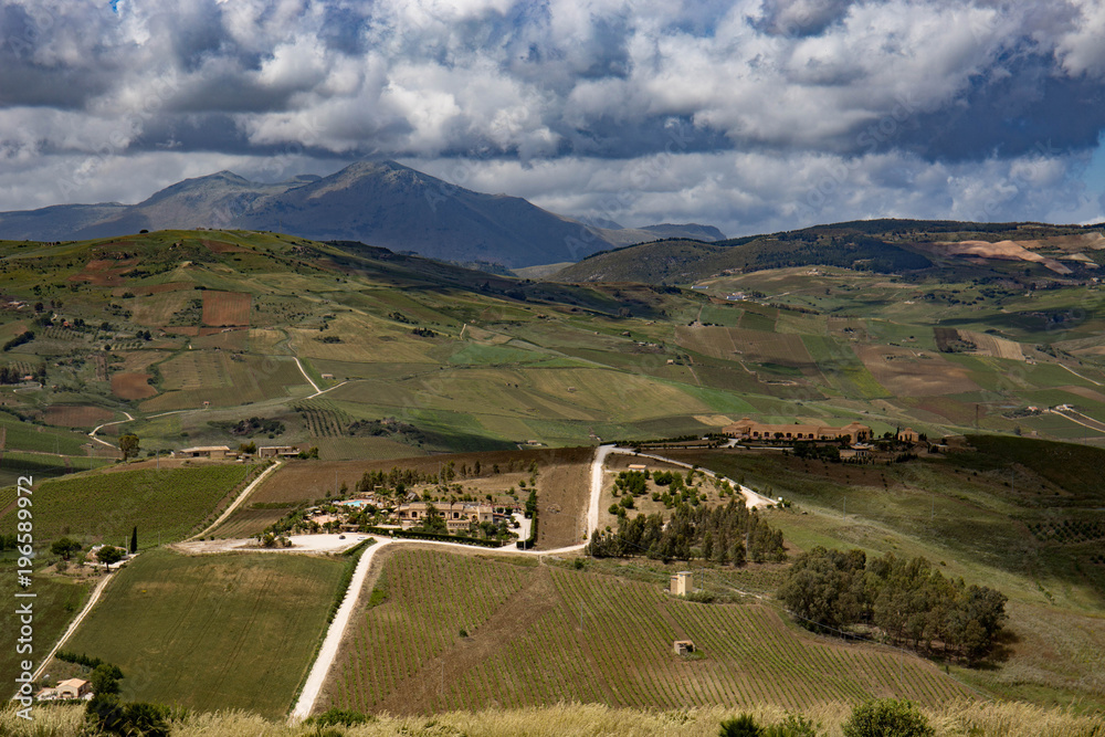 A Sicilian farmhouse lies far down in the valley below.