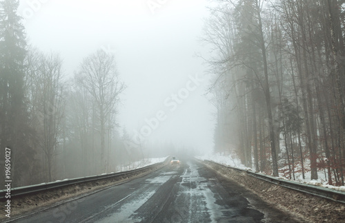 Foggy road in the mountains. Winter trip to the Carpathian Mountains, Eastern Europe