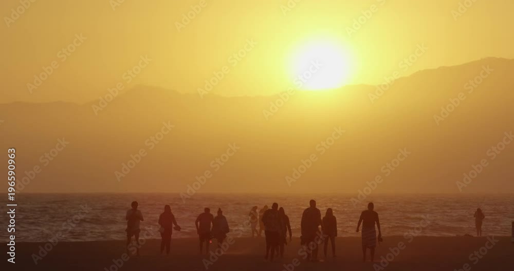 Tourists on the beach at sunset
