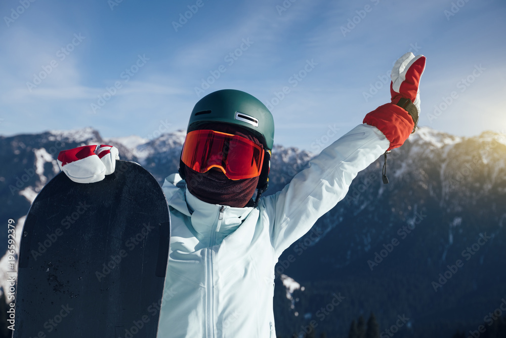 happy snowboarder with snowboard on winter mountain top