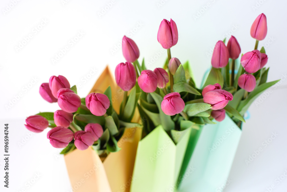Fototapeta premium Bouquets of tulips in paper multi-colored packages. Spring gifts.
