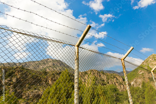 Fence with barbed wire in the open air