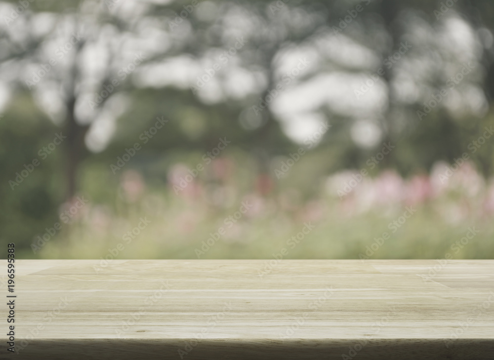 Empty wooden table with blurred pink flower and tree, soft tone Empty wooden table with blurred pink flower and tree, soft tone