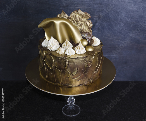 Nice chocolate gilded cake with merengues and sails