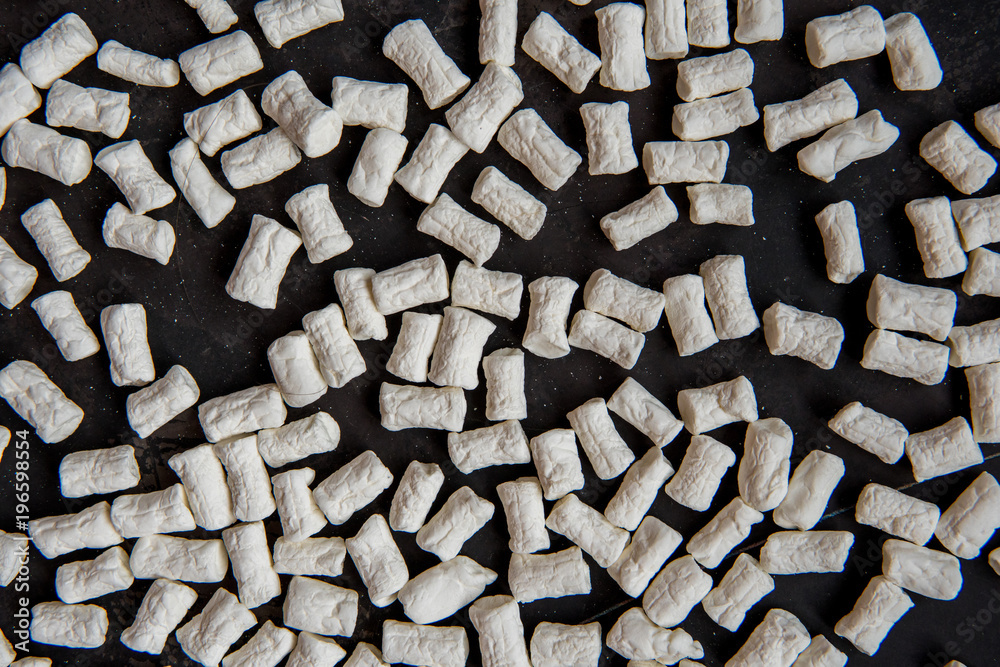 White marshmallow scattered on a dark background White marshmallow scattered on a dark background