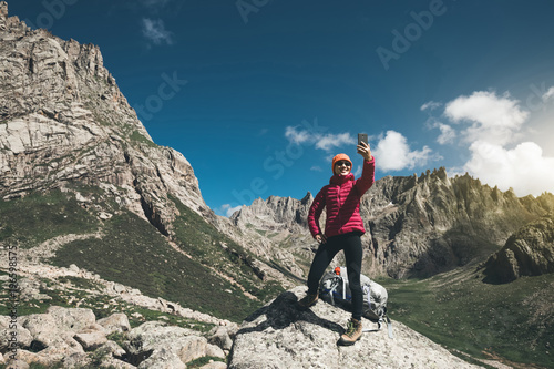 successful woman hiker use smartphone in mountain top rock