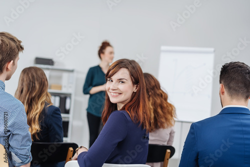 Smiling woman in classroom during seminar