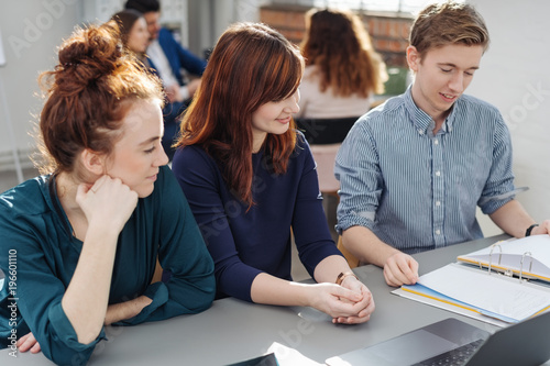 Happy college students working as a team at a desk