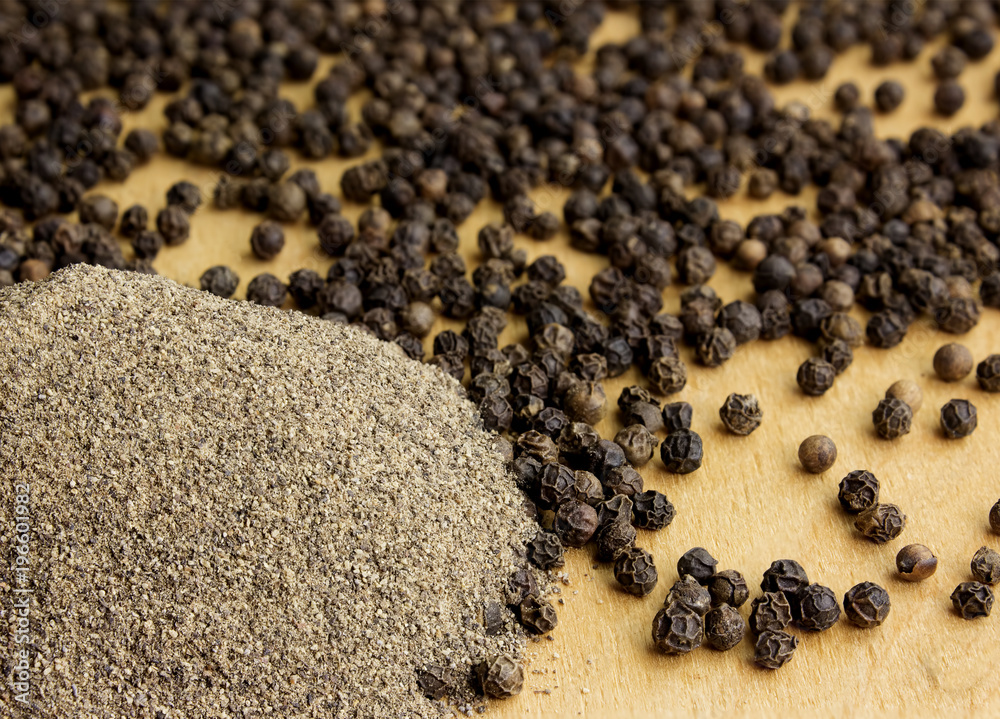 Pile of black pepper on a wooden table Pile of black pepper on a wooden table