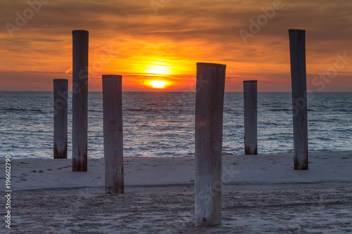 Wooden piles on an empty beach and a beautiful sunset sky over the sea  Petten  Holland North Sea