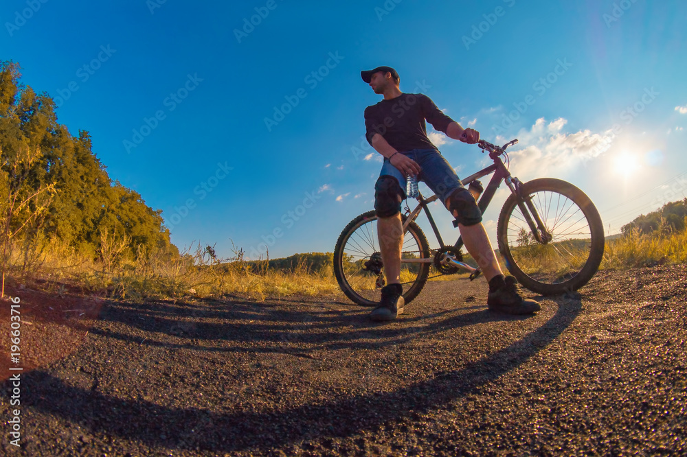Young caucasian athletic man in a knee pads relies on a sports bike Young caucasian athletic man in a knee pads relies on a sports bike