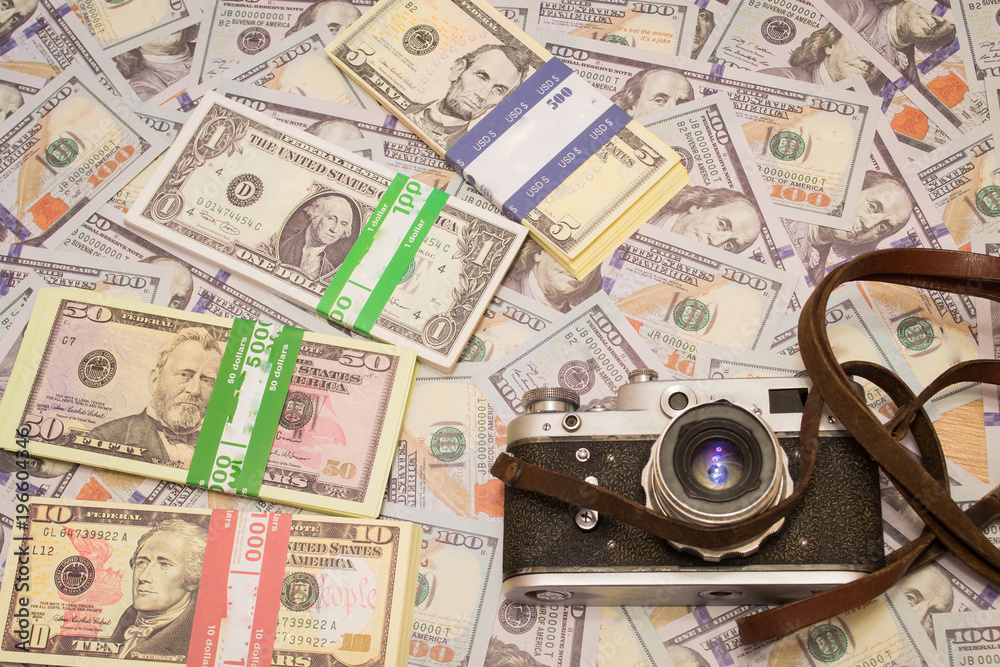 A retro camera on the background of money. Hobby and business in one photo A retro camera on the background of money. Hobby and business in one photo