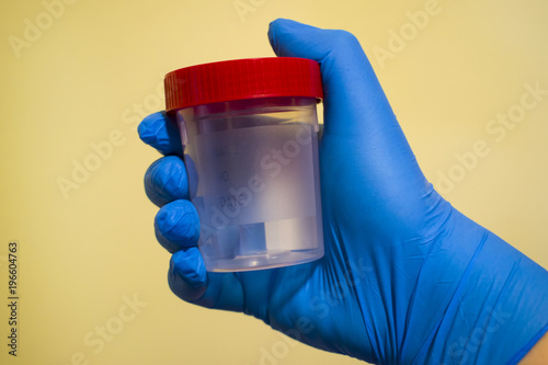 Photos Close-up of a plastic flask in hands.