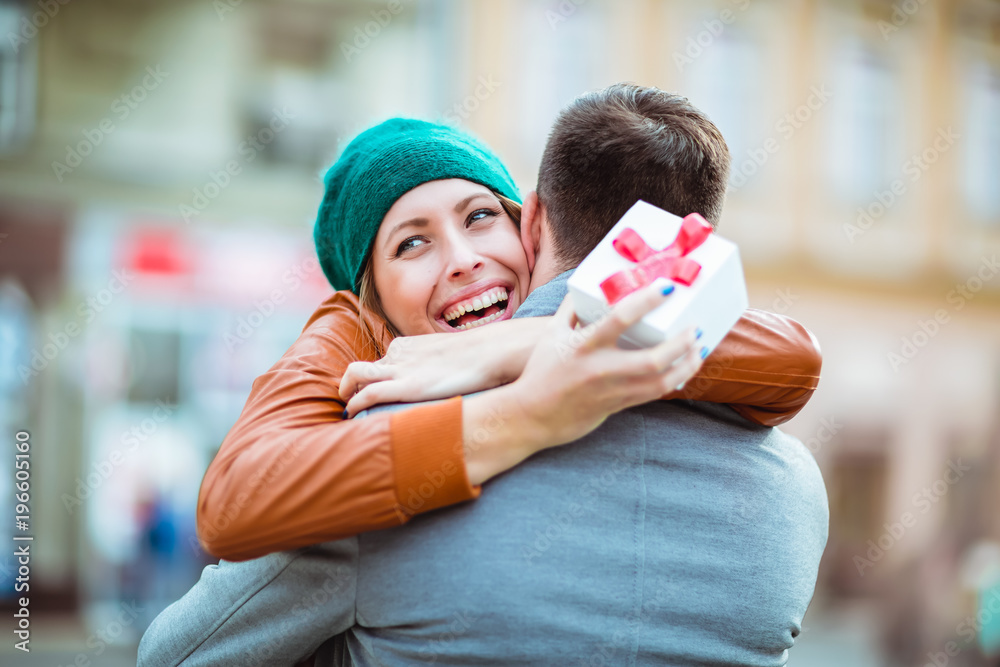 Couple in love.Man surprising his girlfriend with a gift. Couple in love.Man surprising his girlfriend with a gift.