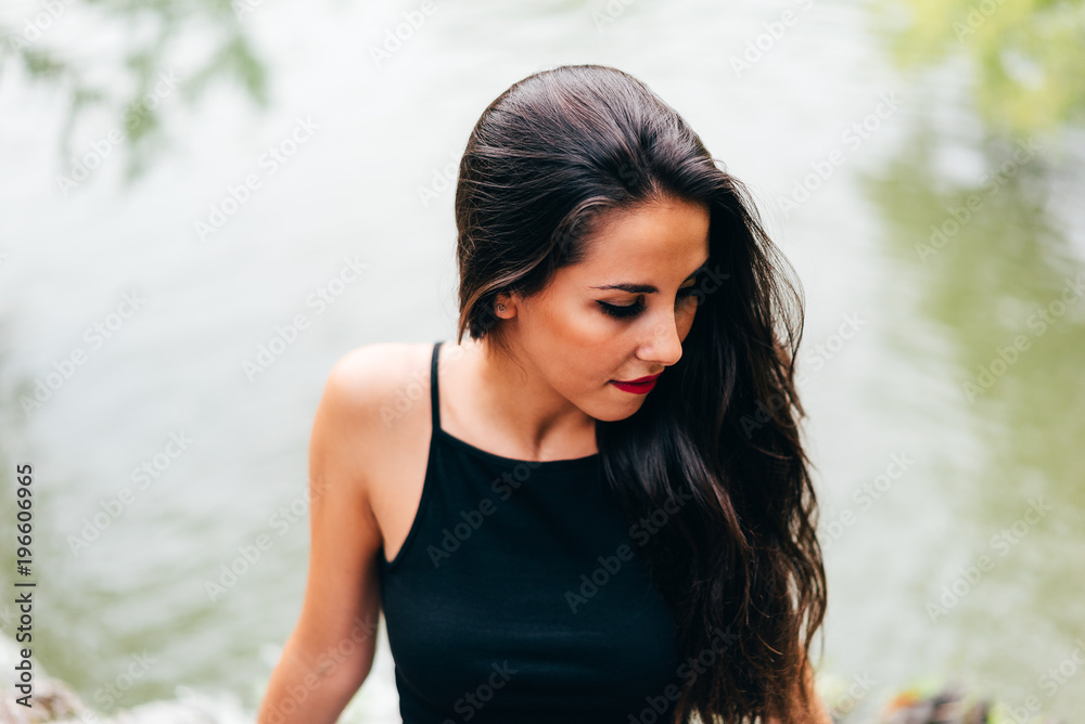Brunette woman leaning on handrail at river Brunette woman leaning on handrail at river
