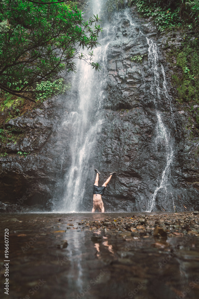 Man standing on hands at cascade Man standing on hands at cascade