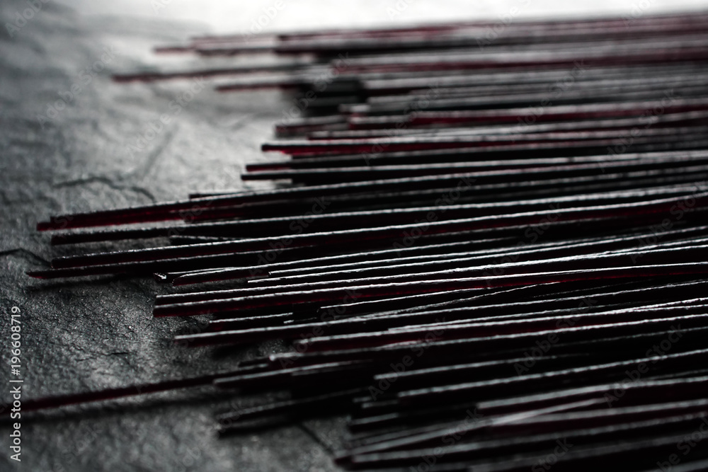 Black dry rice noodles on black stone close-up Black dry rice noodles on black stone close-up