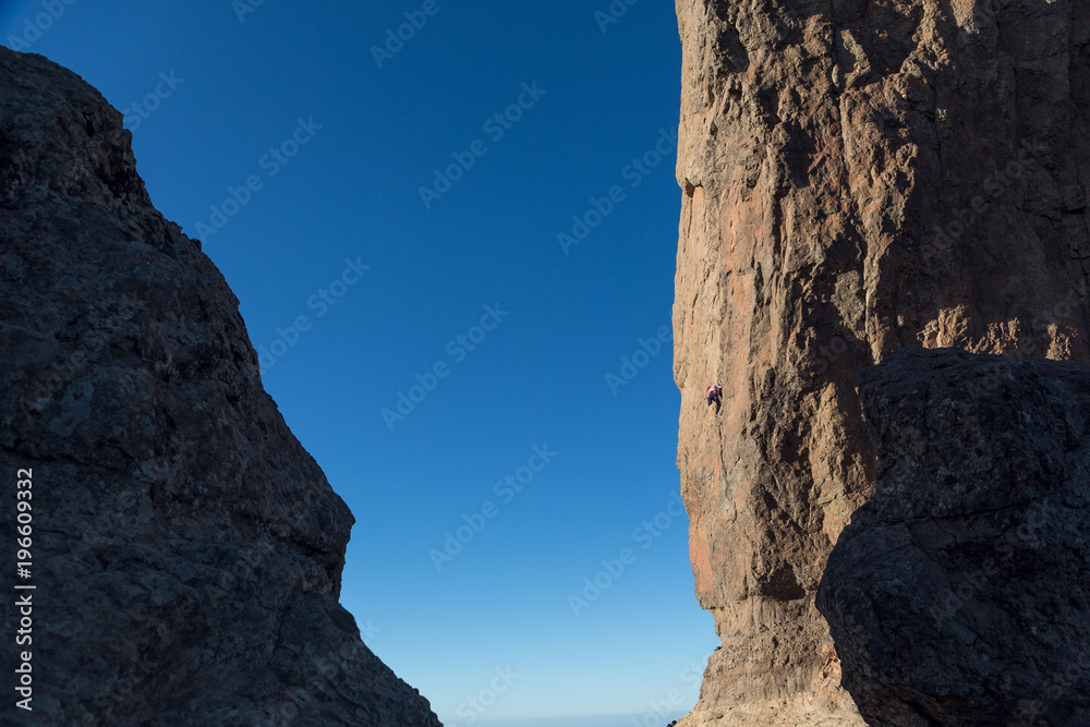 Rock climber on a mountain Roque Nublo. Mountain climbing