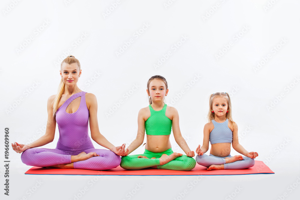 Hatha yoga fitness . Young mother Instructor and daughters exercise gymnastic together. Isolated on white background. Family look.