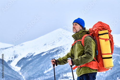 Winter climb to the top of the mountain with a backpack.